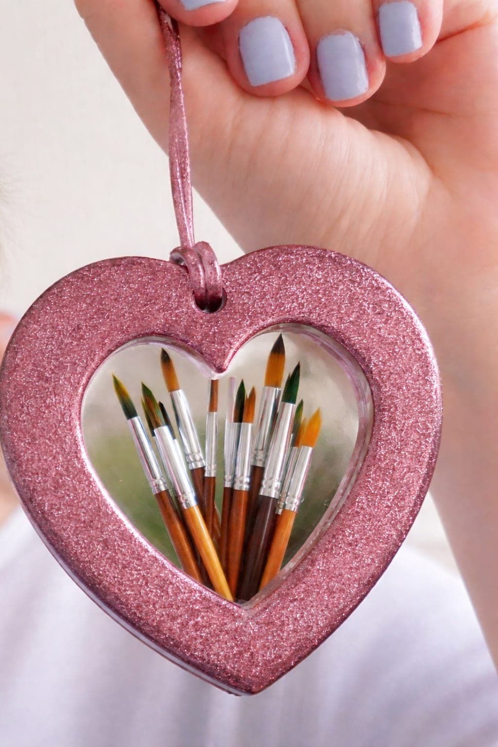 Pinceles de acuarela dentro de un corazón rosa